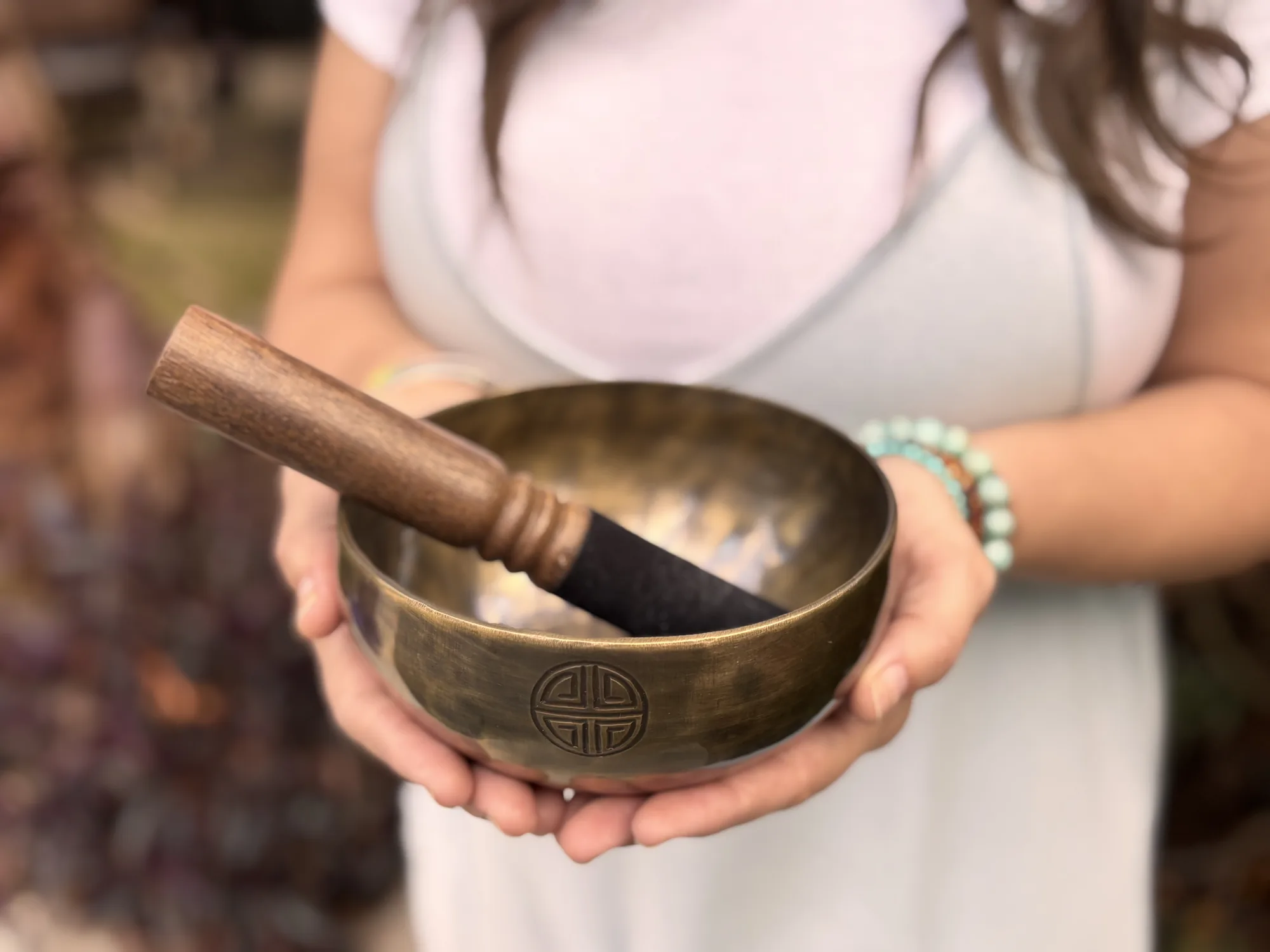 Hands holding an antique brass singing bowl