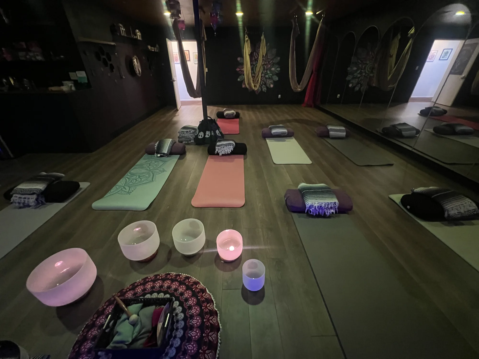 A studio prepared for a group sound bath with mats, bolsters and crystal singing bowls